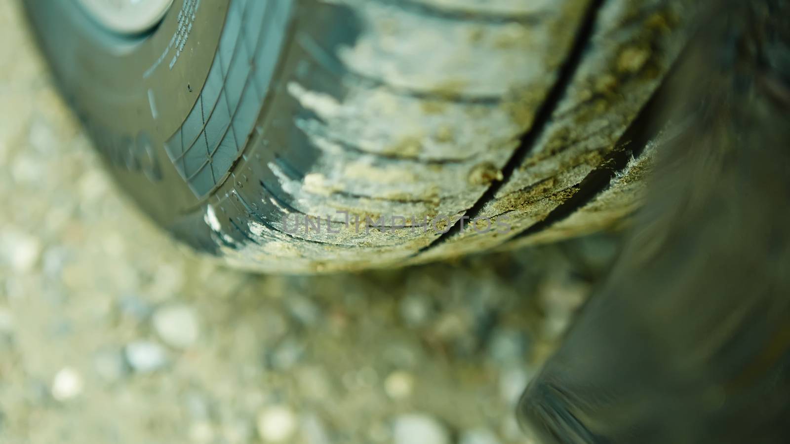 detail of a car wheel and some mud tainting the car