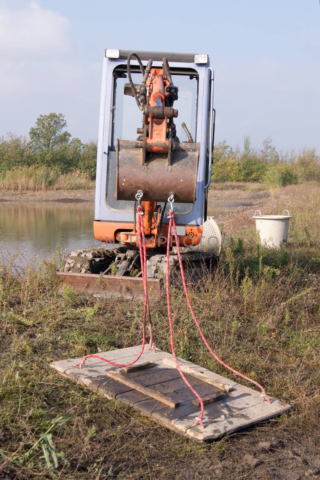 The crawler excavator operator stopped by the lake.