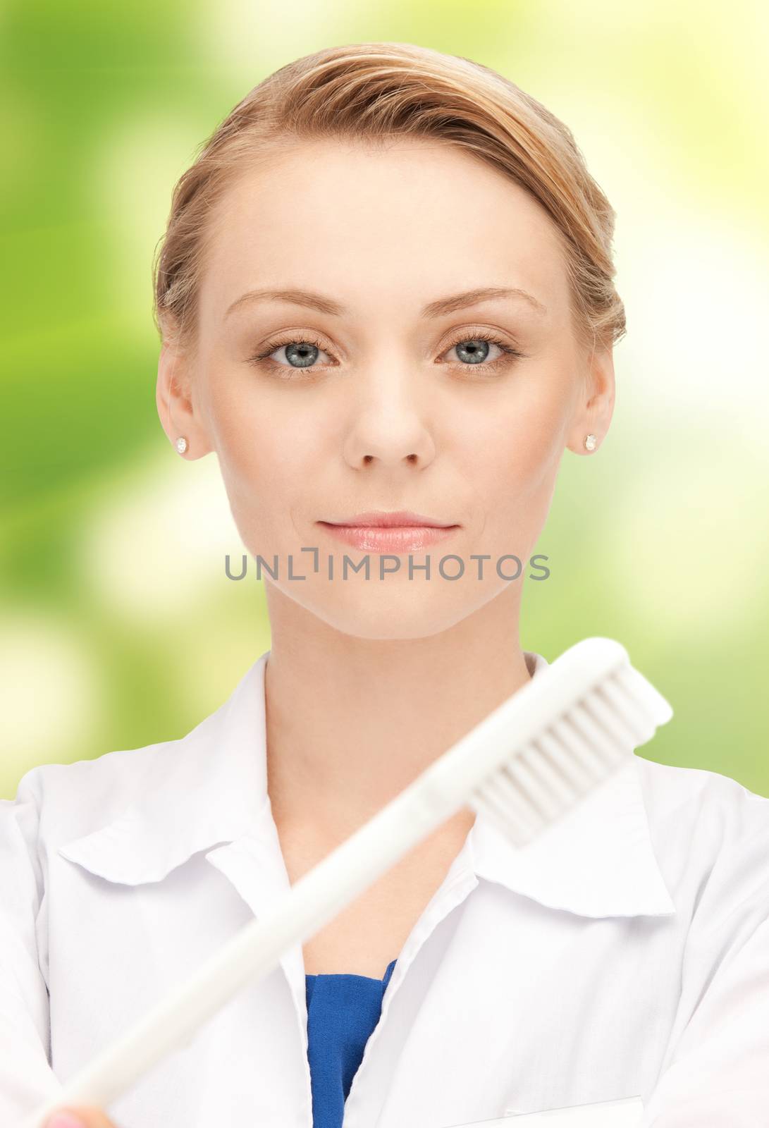 people, medicine, stomatology and healthcare concept - happy young female dentist with tooth brush over green background