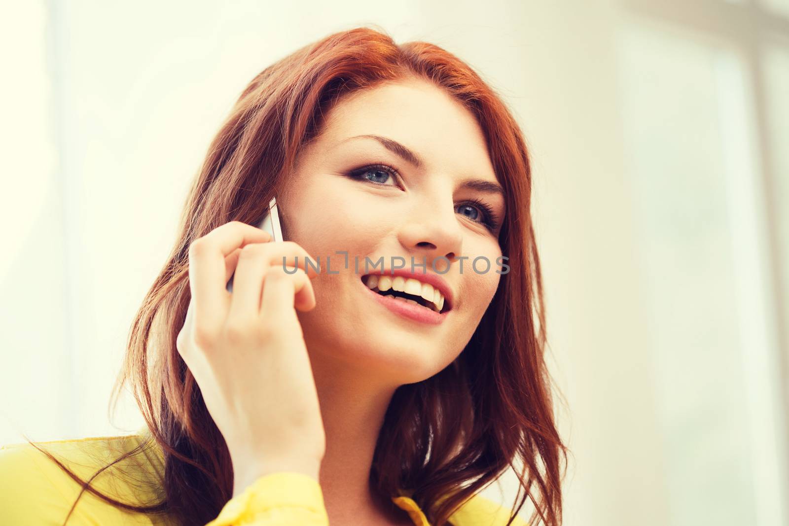 smiling teenage girl with smartphone at home by dolgachov