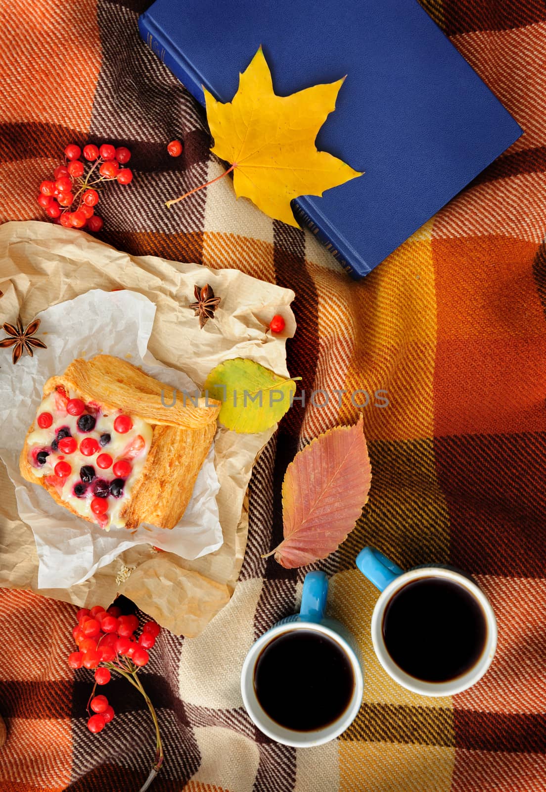 Romantic autumn still life with blanket, cake, book, coffee cups and leaves, top view