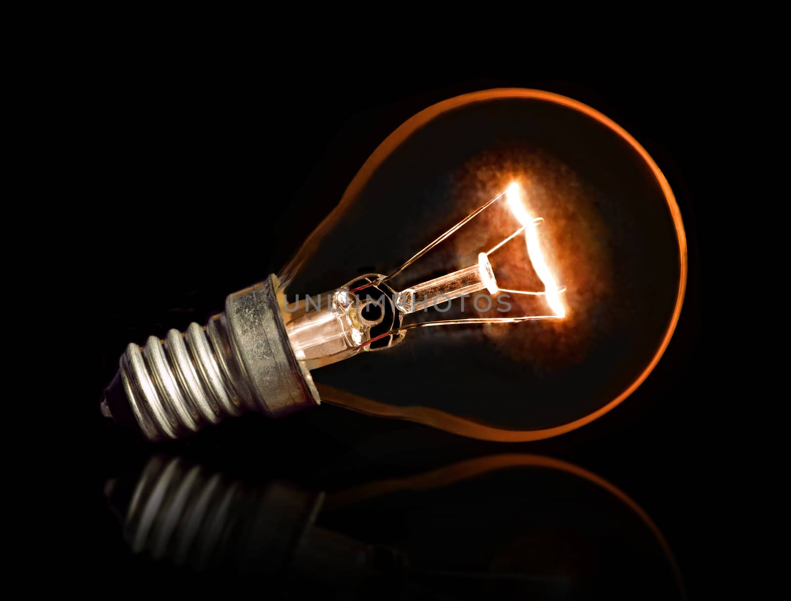 Light Bulb with awesome glare and reflection isolated against black background - business energy saving concept.