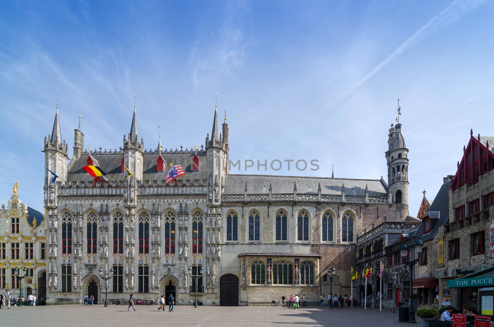 Bruges, Belgium - May 11, 2015: Tourist on Burg square with City Hall and Basilica of the Holy Blood in Bruges by siraanamwong