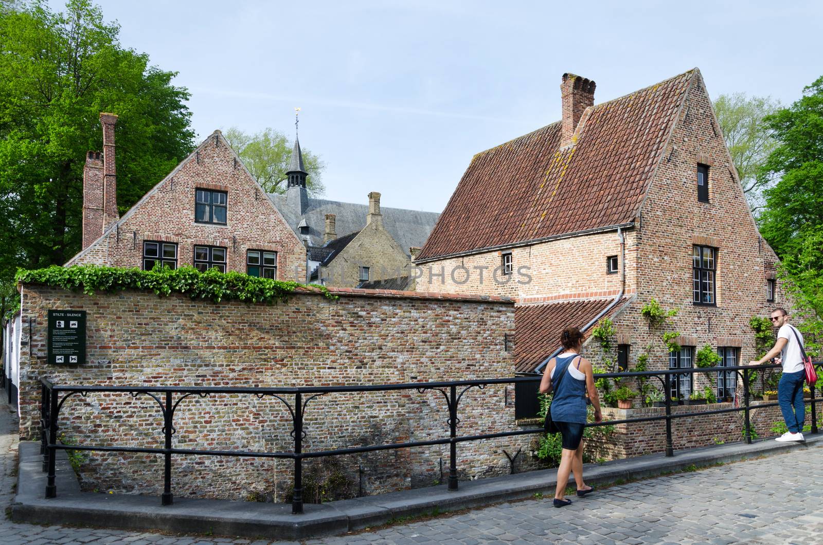 Bruges, Belgium - May 11, 2015: People around the Beguinage (Begijnhof) in Bruges, Belgium. by siraanamwong
