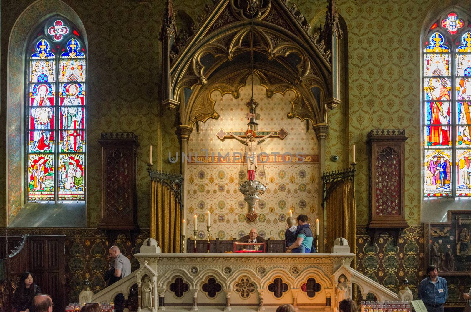 Bruges, Belgium - May 11, 2015: Tourists visit Interior of Basilica of the Holy Blood in Bruges by siraanamwong