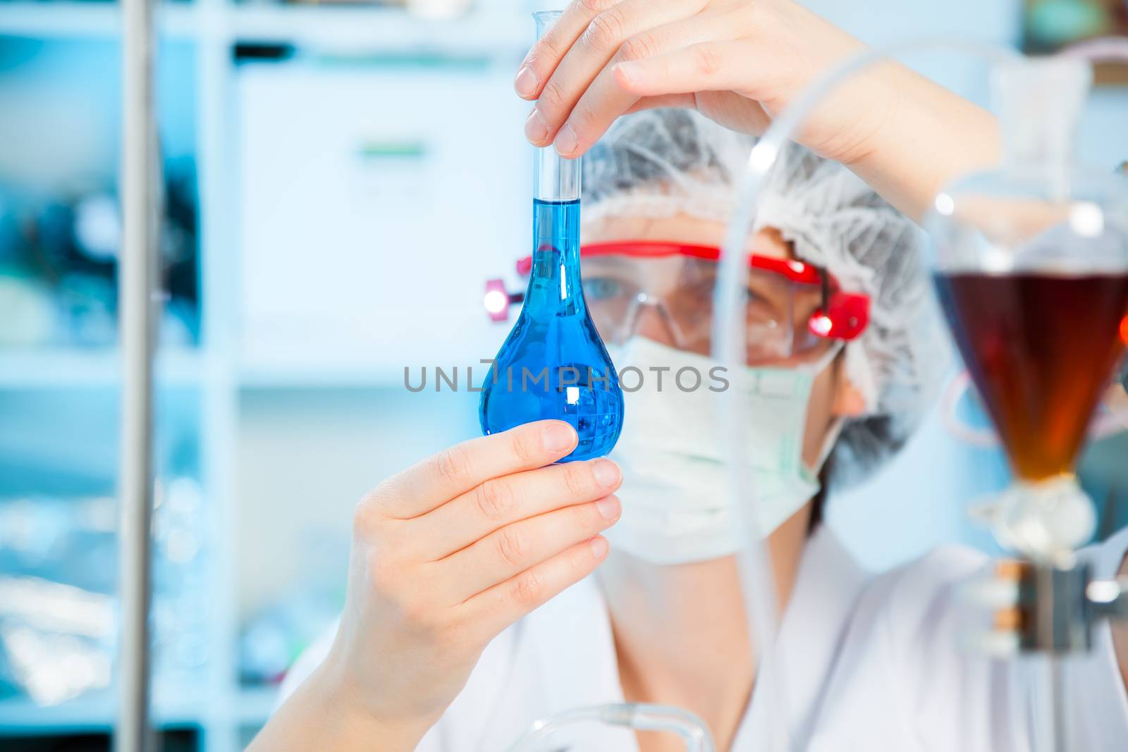 Scientific researcher holding at a liquid solution in a lab