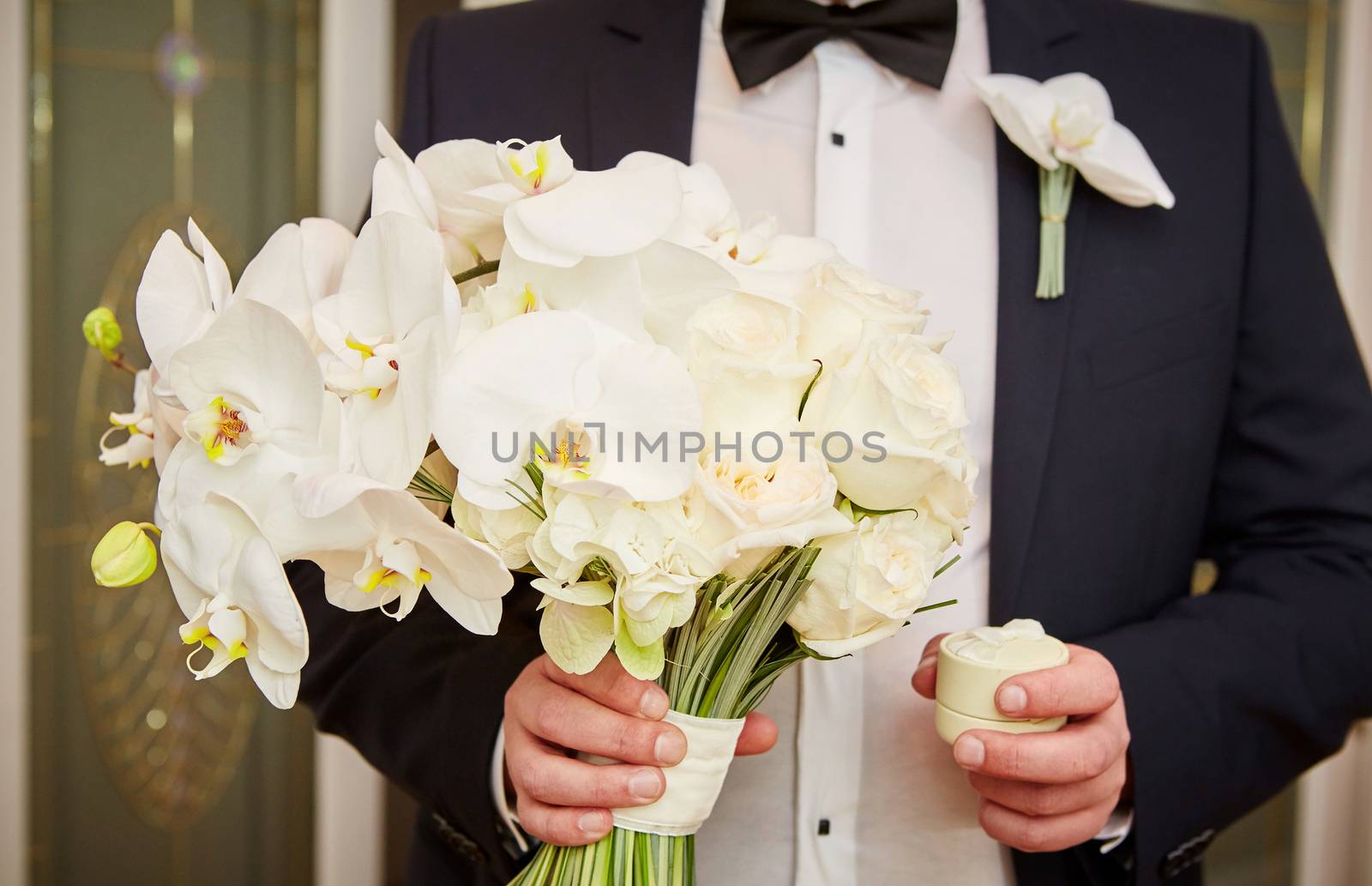 The groom with wedding rings and bouquet