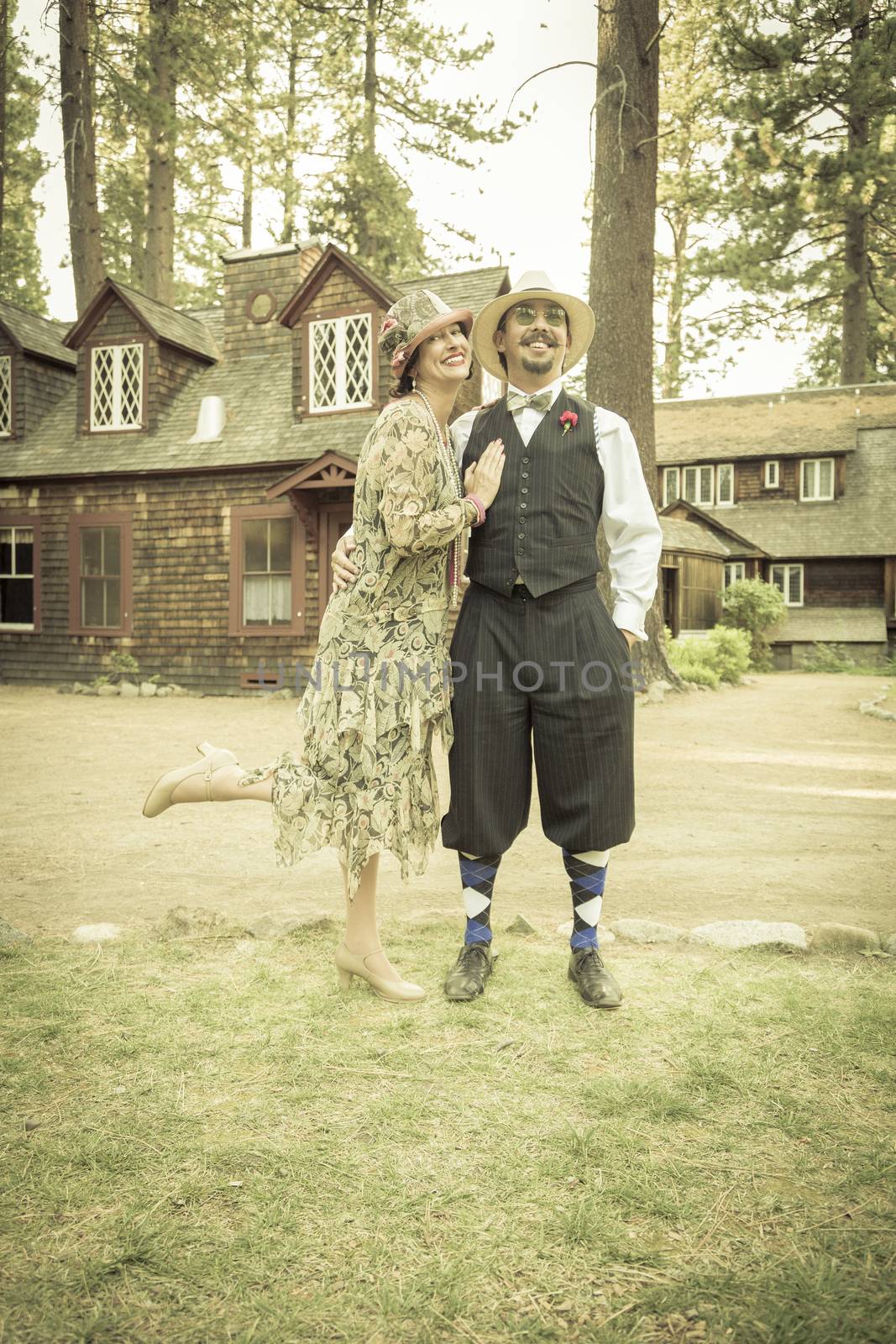 Attractive 1920s Dressed Romantic Couple in Front of Old Cabin Portrait.