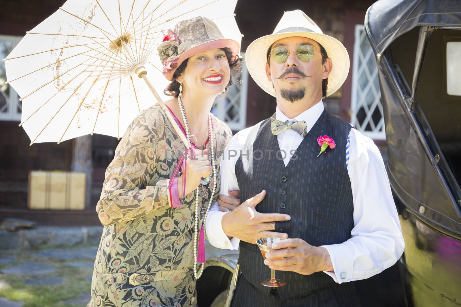 Attractive Mixed-Race Couple Dressed in 1920’s Era Fashion Sipping Champagne.