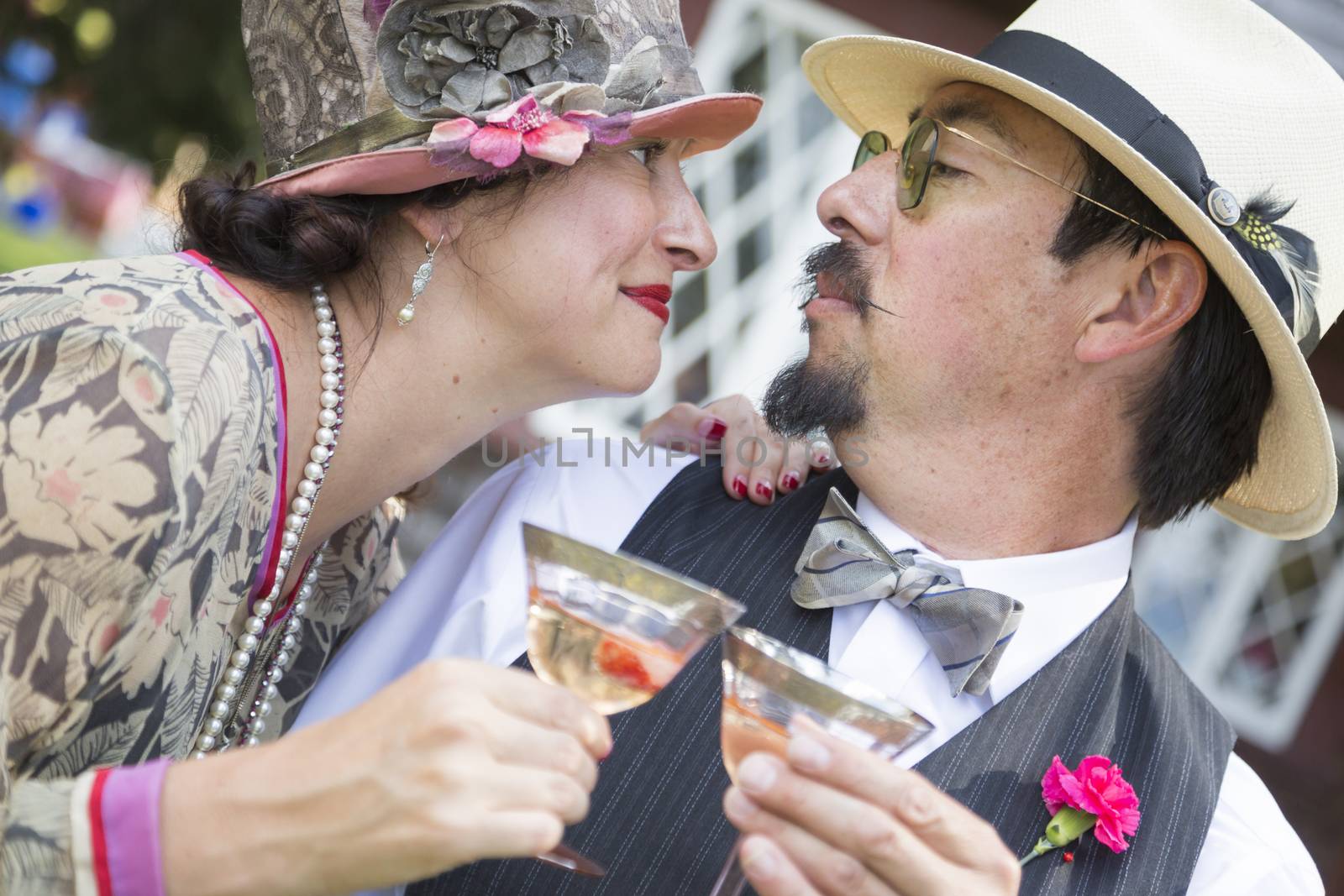 Attractive Mixed-Race Couple Dressed in 1920’s Era Fashion Sipping Champagne.