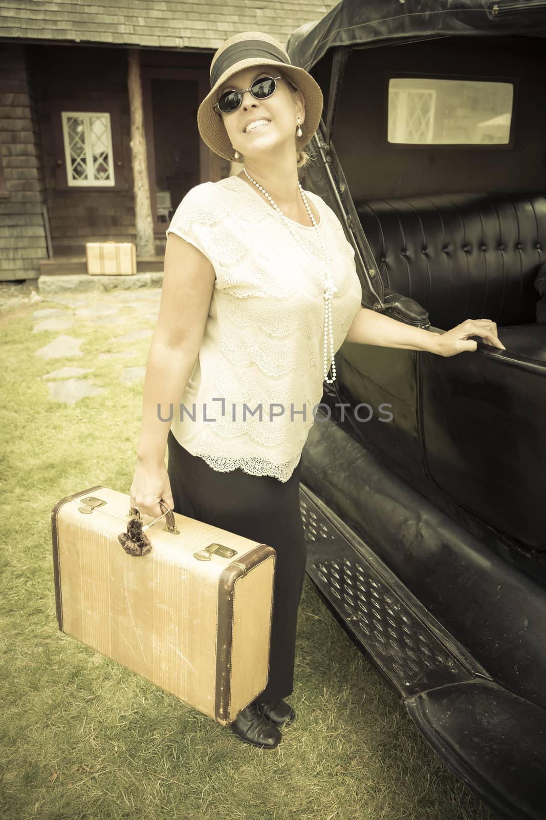 Happy 1920s Dressed Girl Holding Suitcase Next to Vintage Car and Cabin.