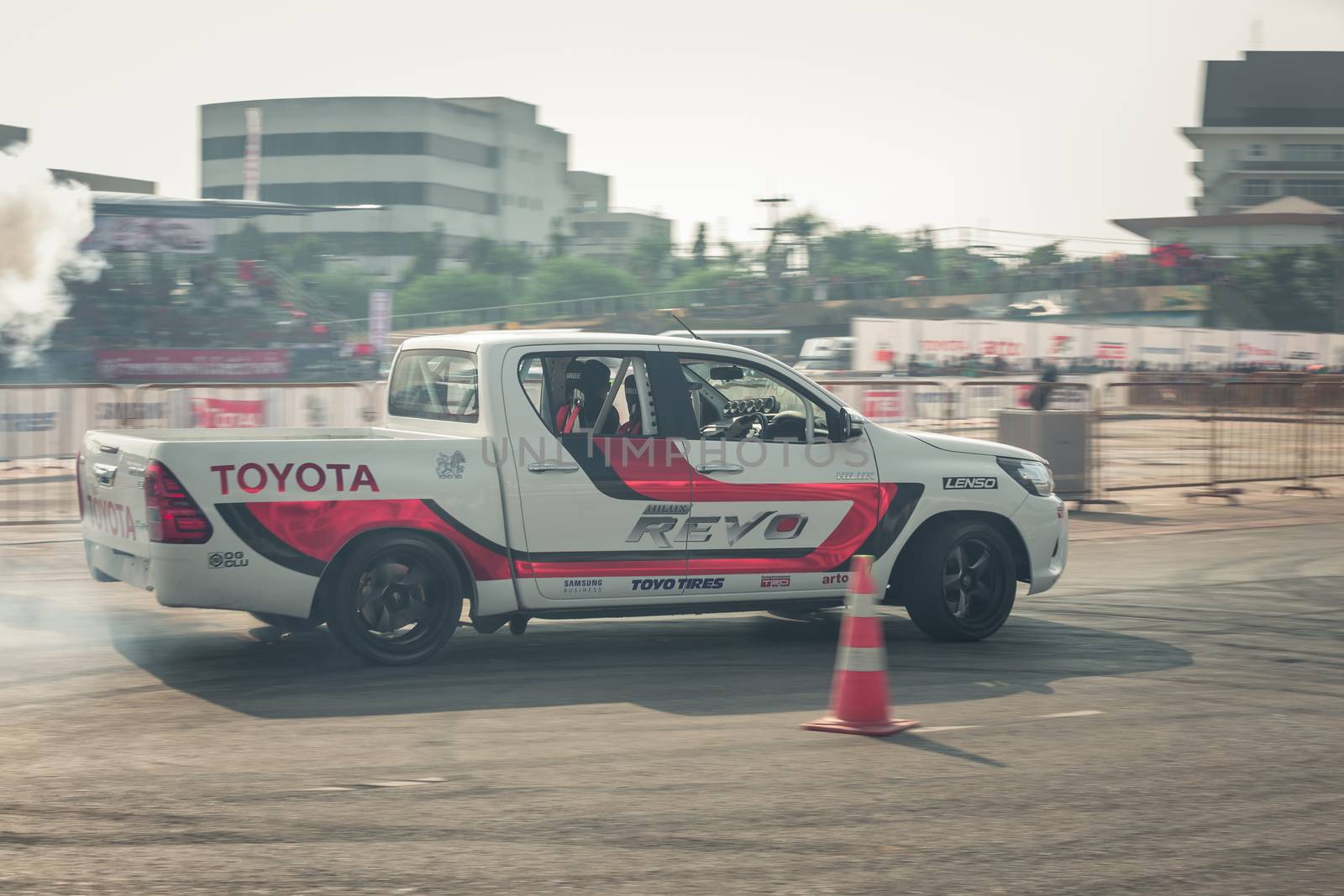 Udon Thani, Thailand - October 18, 2015: Toyota Hilux Revo perform drifting contest on the track between driver from Thailand and Japan at the event Toyota Motor Sport show at Udon Thani, Thailand with motion blur of the background