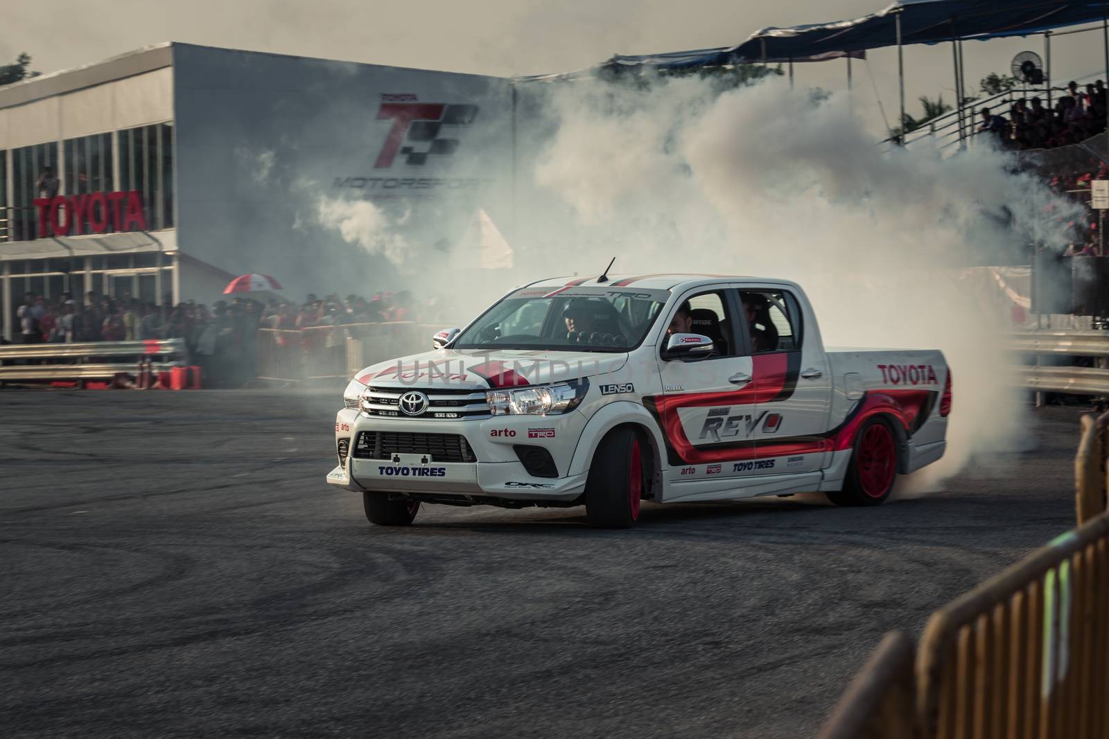 Udon Thani, Thailand - October 18, 2015: Toyota Hilux Revo perform drifting contest on the track between driver from Thailand and Japan at the event Toyota Motor Sport show at Udon Thani, Thailand with motion blur of the background and smoke of the burning tires