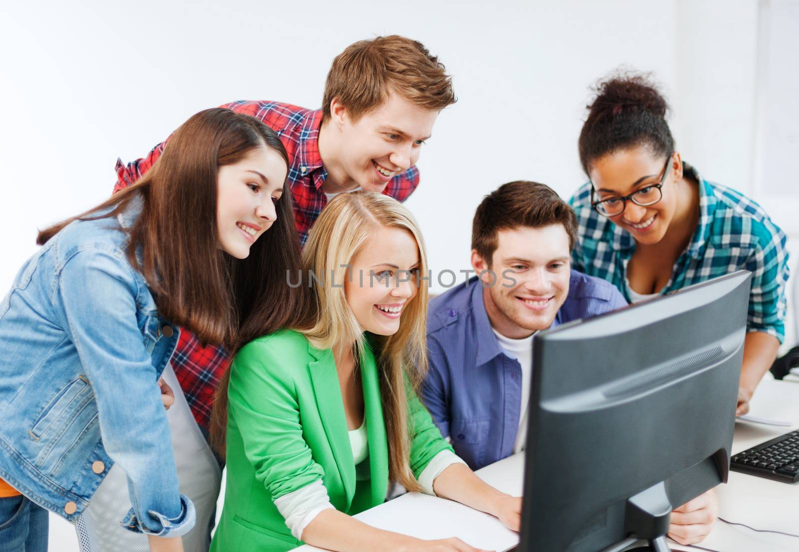 education concept - students with computer studying at school