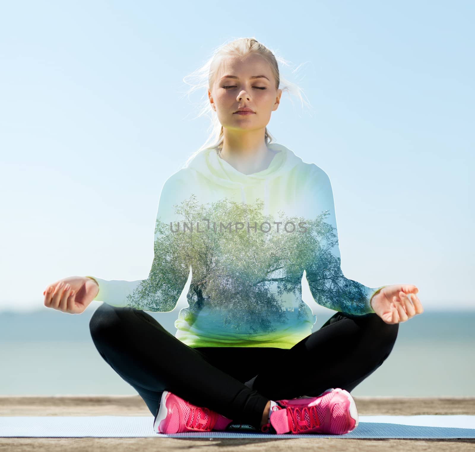 happy young woman doing yoga outdoors by dolgachov