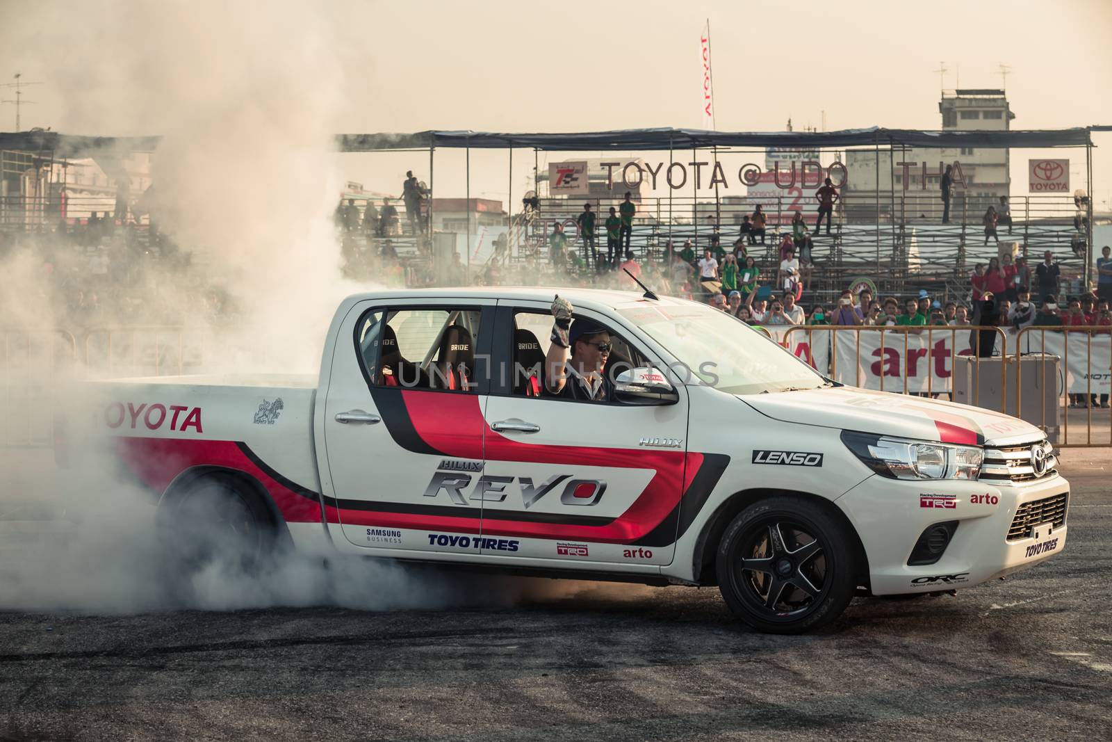 Udon Thani, Thailand - October 18, 2015: Techapol Toyingchareon the driver of Toyota Hilux Revo perform drifting contest on the track between driver from Thailand and Japan at the event Toyota Motor Sport show at Udon Thani, Thailand with  smoke of the burnout tires