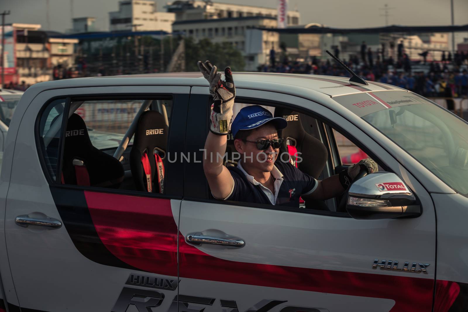 Udon Thani, Thailand - October 18, 2015: Techapol Toyingchareon the driver of Thailand of the Toyota Hilux Revo waving hand to the audiences after drifting contest on the track between driver from Thailand and Japan at the event Toyota Motor Sport show at Udon Thani, Thailand  with motion blur in the background