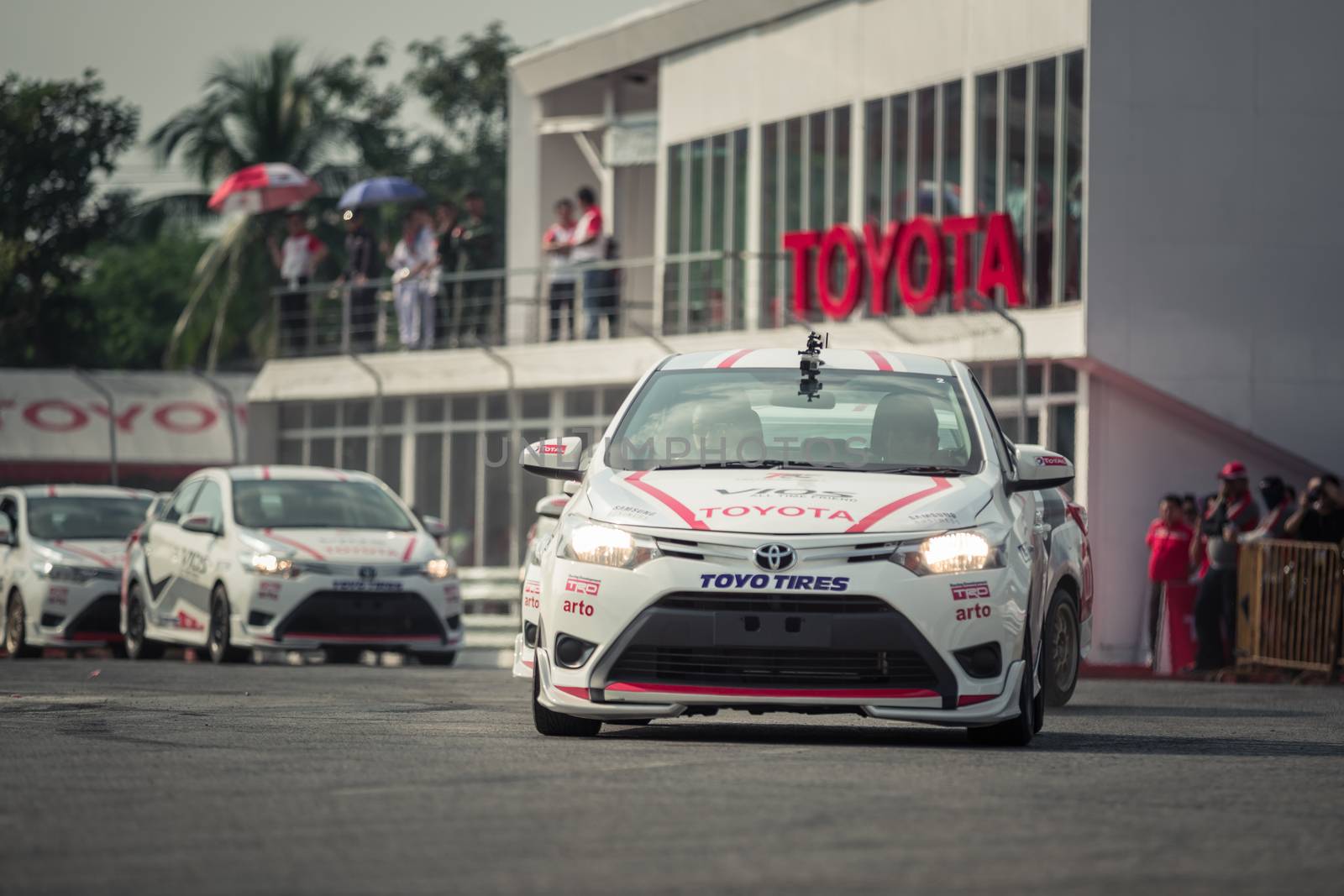 Udon Thani, Thailand - October 18, 2015: Toyota Colora Altis perform drifting on the track at the event Toyota Motor Sport show at Udon Thani, Thailand with people looking in the background