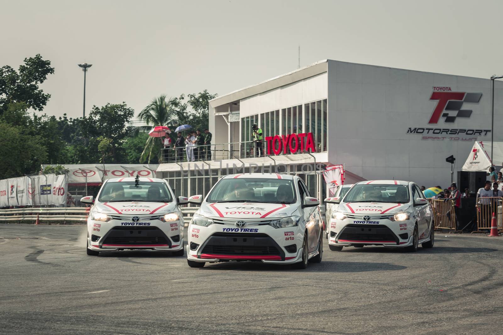 Udon Thani, Thailand - October 18, 2015: Toyota Colora Altis perform drifting on the track at the event Toyota Motor Sport show at Udon Thani, Thailand with people looking in the background