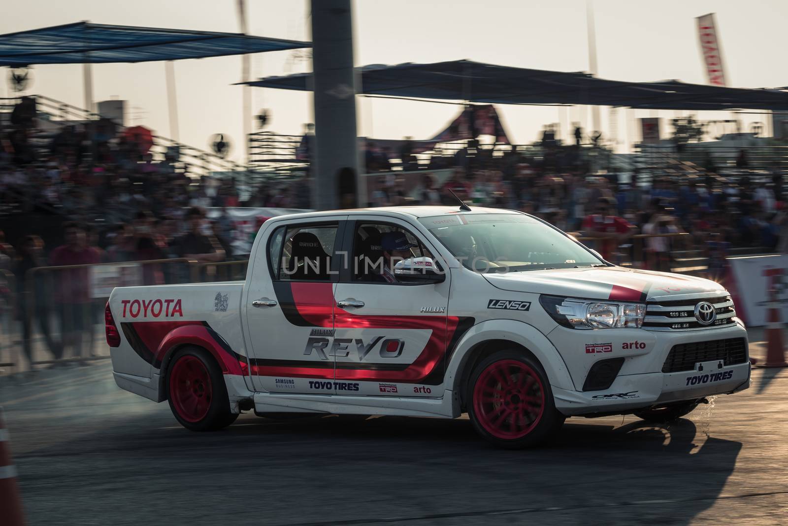 Udon Thani, Thailand - October 18, 2015: Masato Kawabata the driver of Toyota Hilux Revo perform drifting contest on the track between driver from Thailand and Japan at the event Toyota Motor Sport show at Udon Thani, Thailand with motion blur of the background and smoke of the burning tires