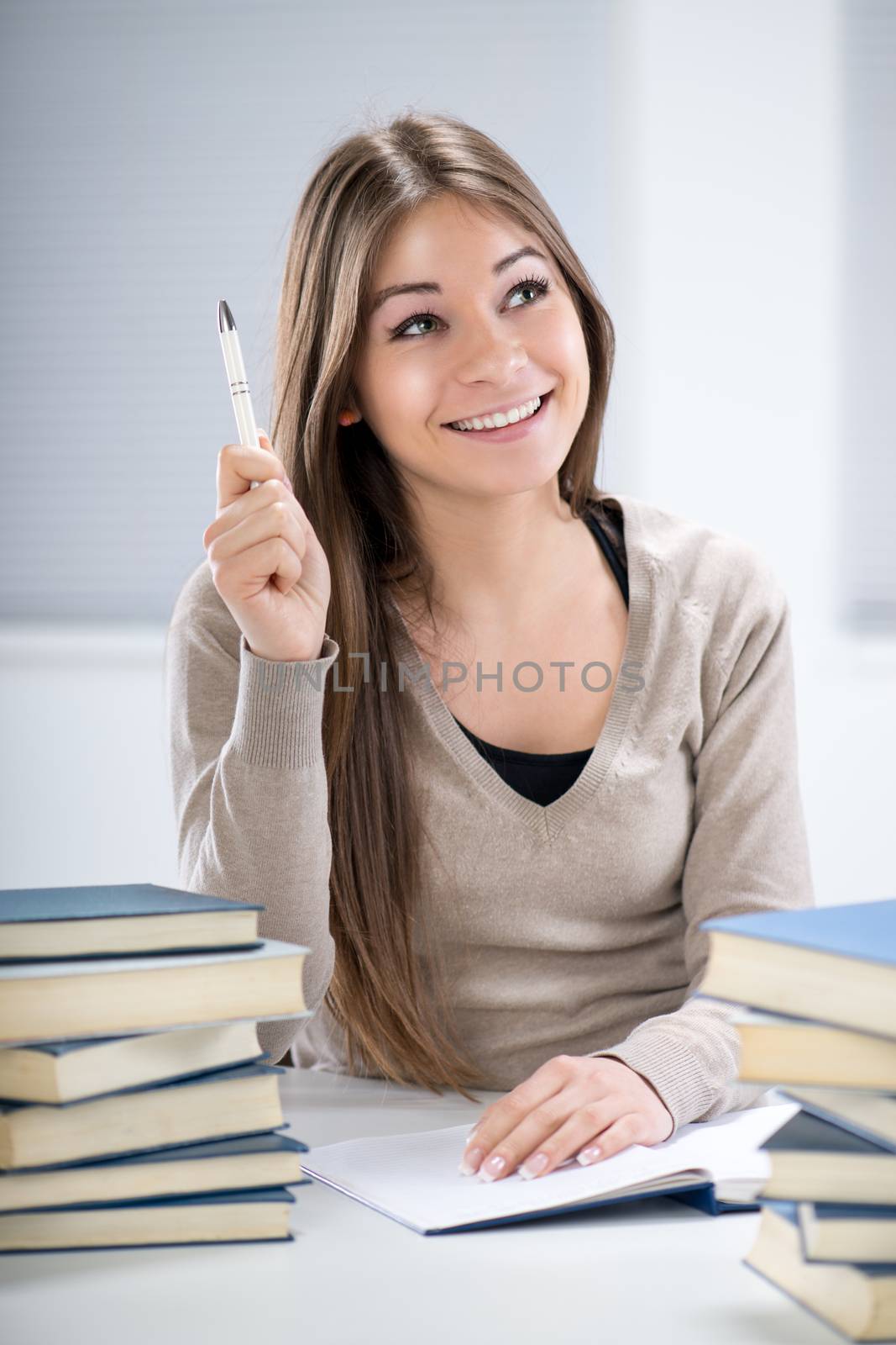Beautiful Student girl sitting with many books, learning and having brilliant idea.