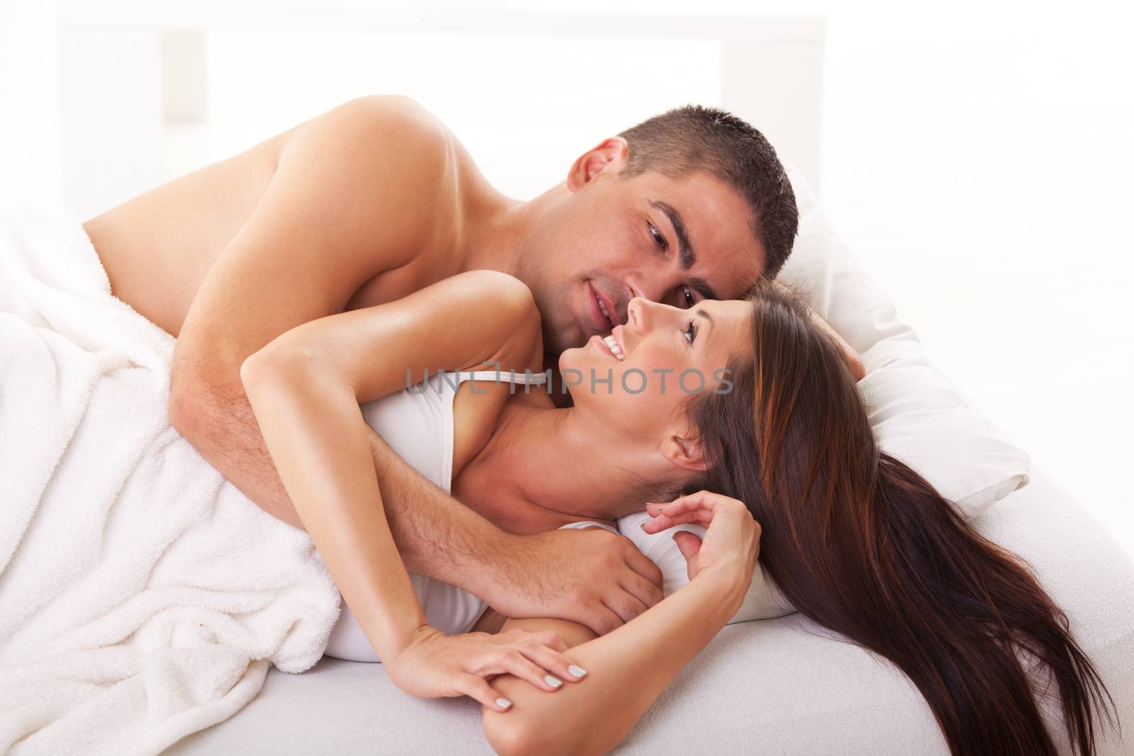 Young couple in love lying in bed and relaxing.