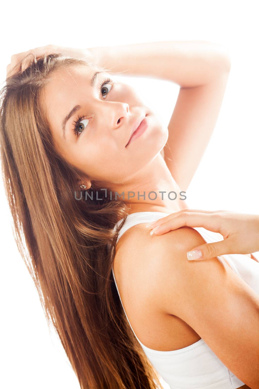 Portrait of a Young cute brunette gently touching her shoulders and hair.