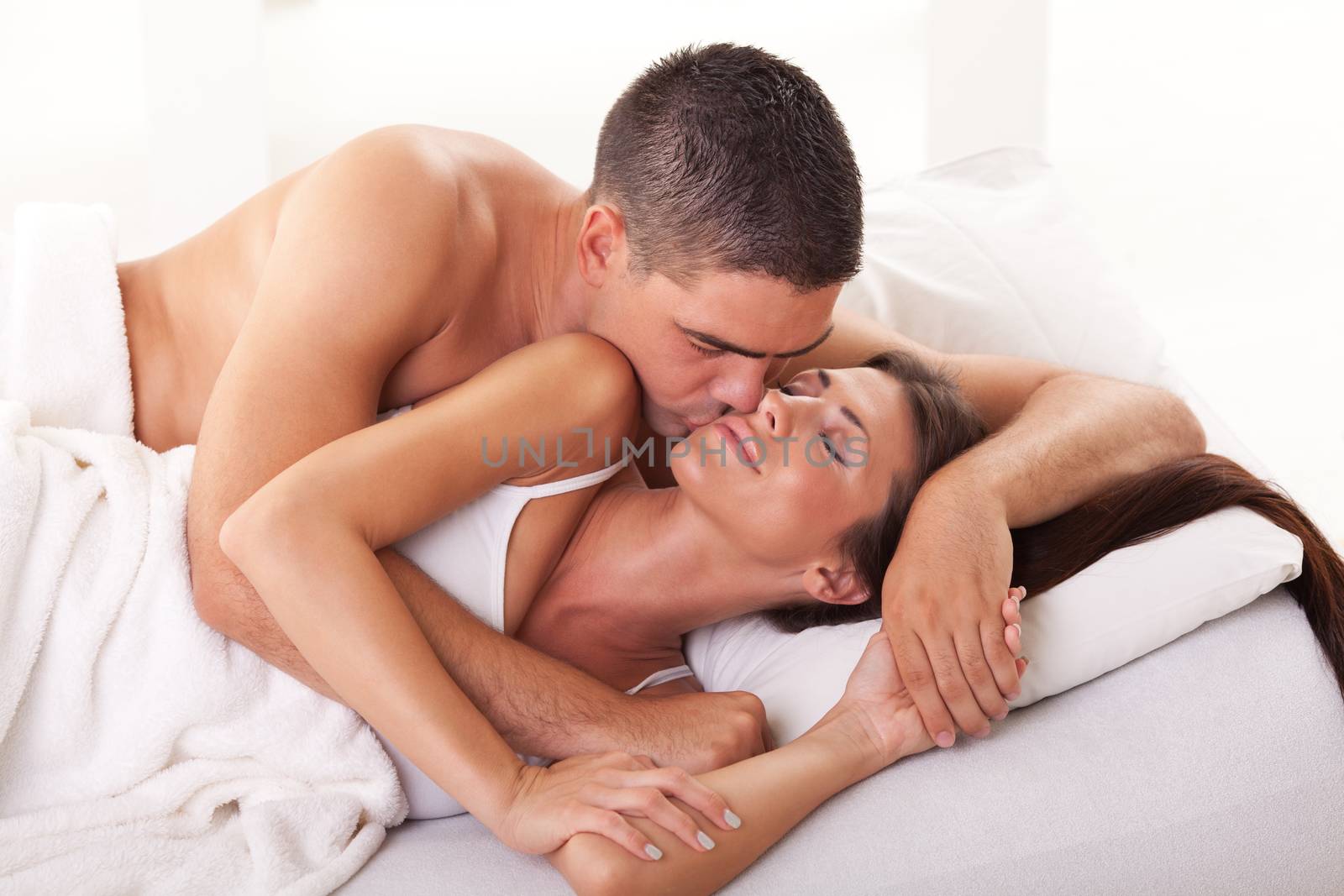 Young man kissing his girlfriend for a good morning.