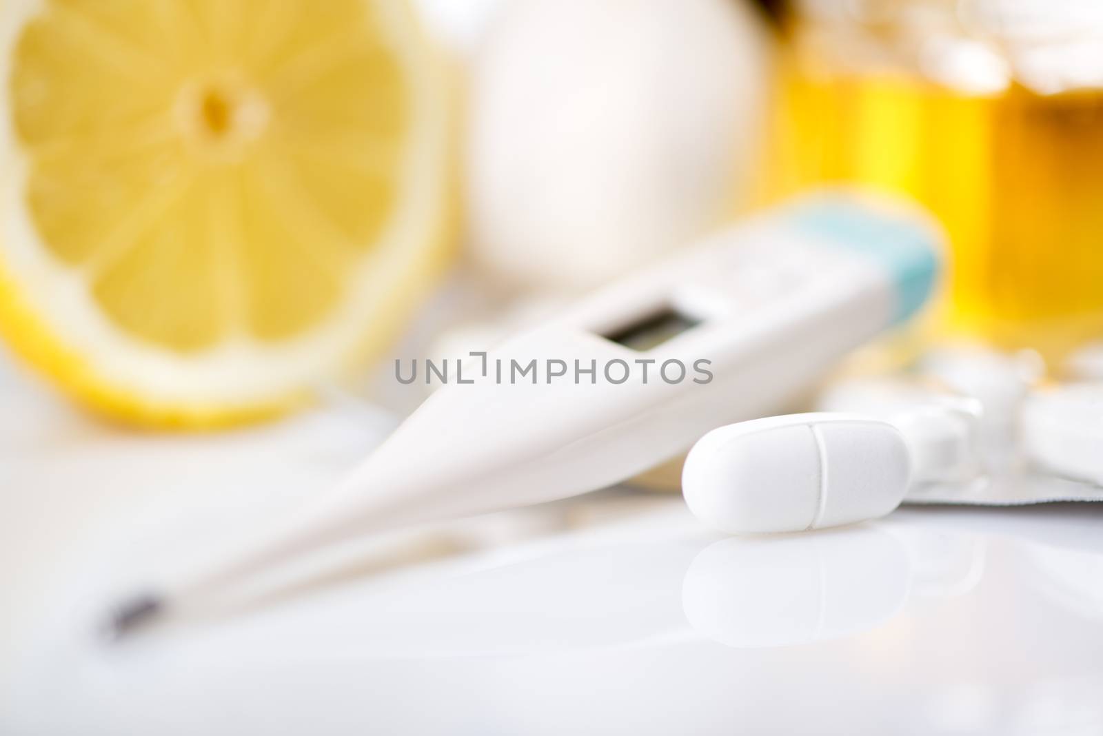Vitamins and pills for treatment Cold And Flu. Lemon,  honey and Thermometer on white background.