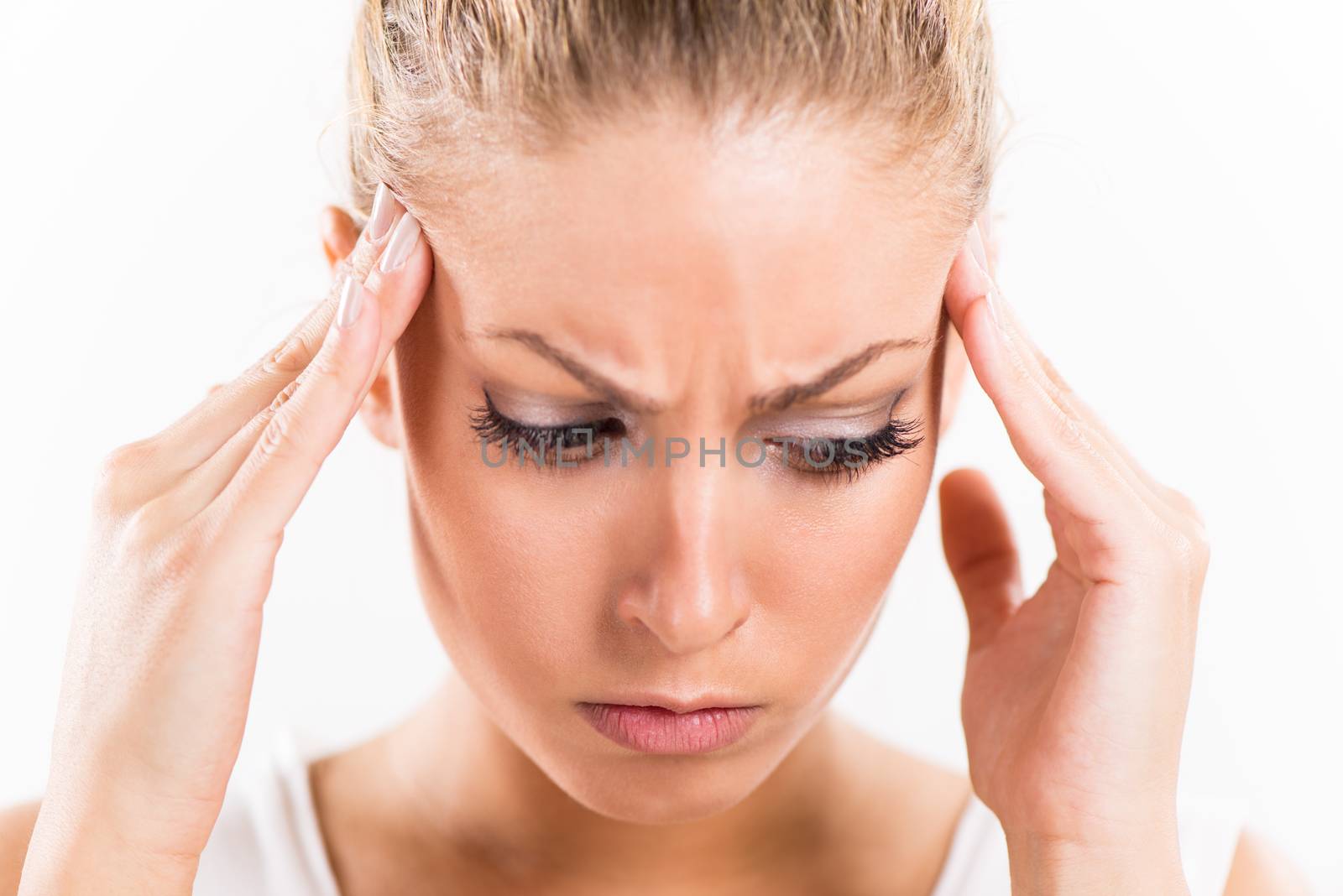 Portrait of a beautiful young woman with hands on head relieve a headache.