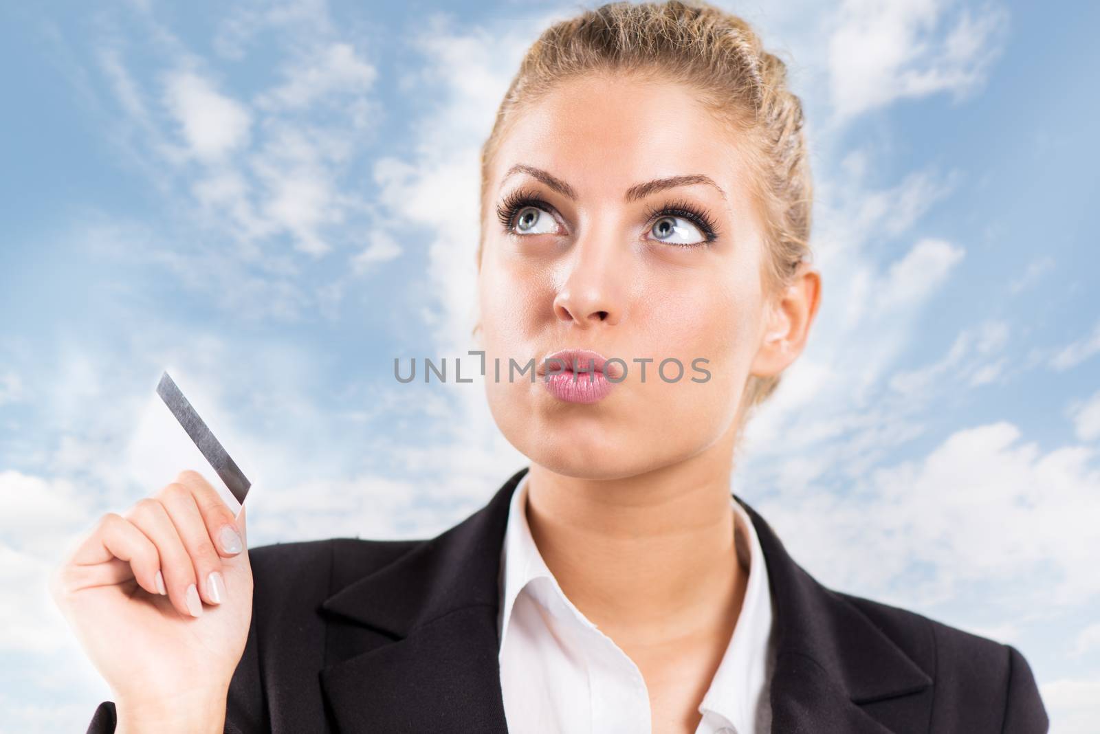 Beautiful Businesswoman holding a credit card and thinking.