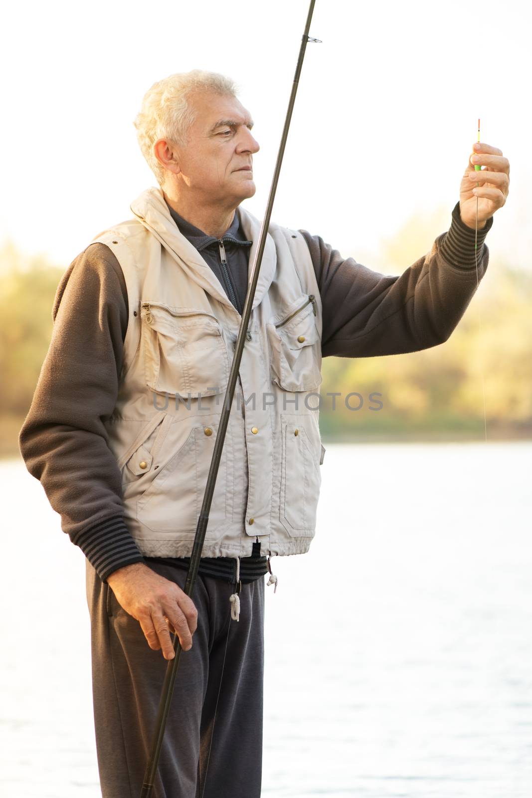 Senior men fishing by the lake.