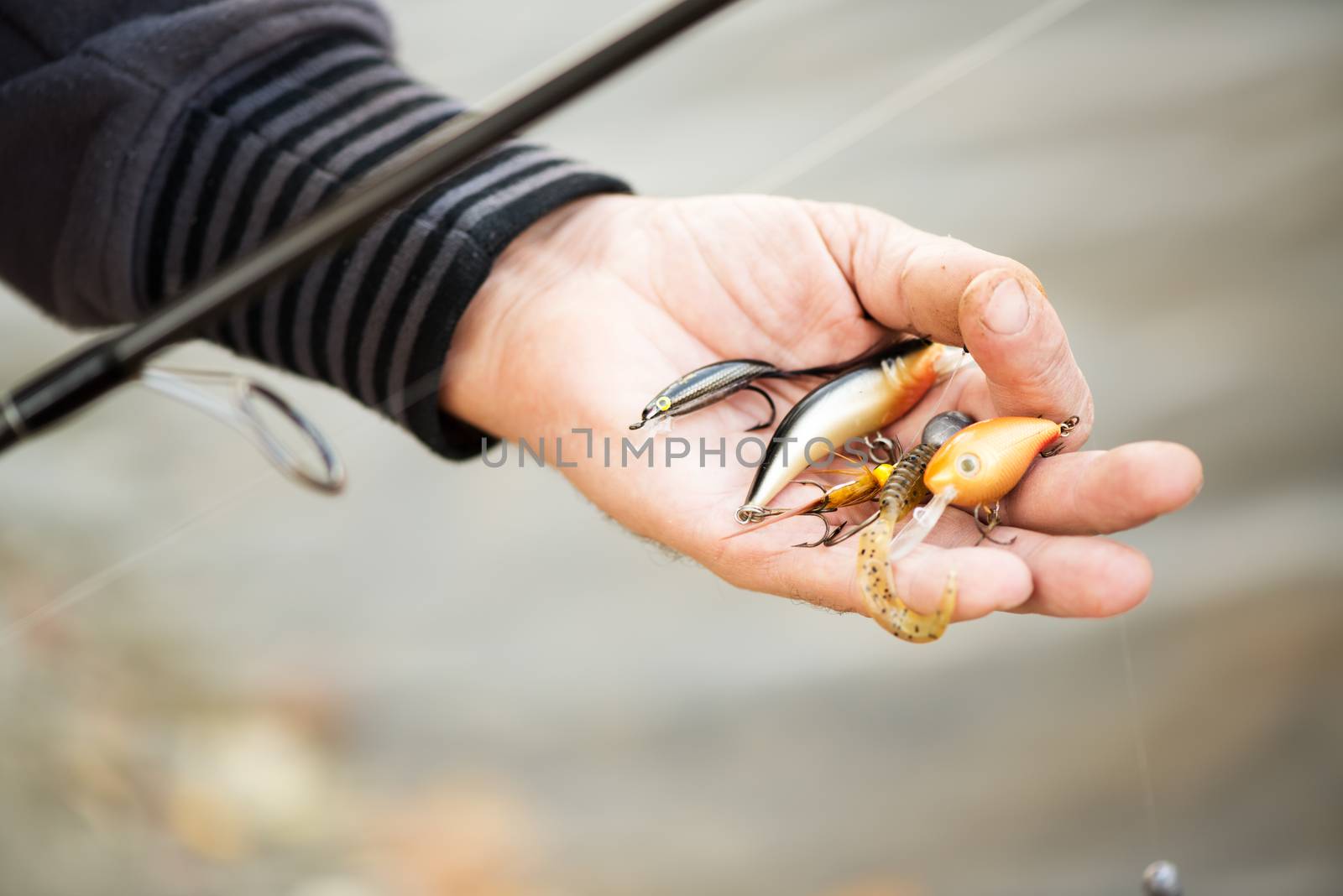 Fisherman holding many Fishing lures.