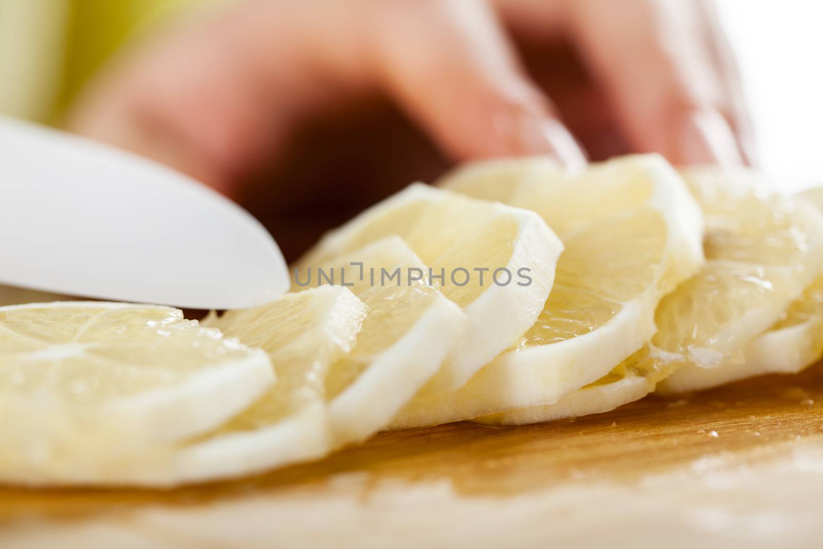 Female hands Cutting Lemon in a kitchen. Close-up.  Selective Focus.