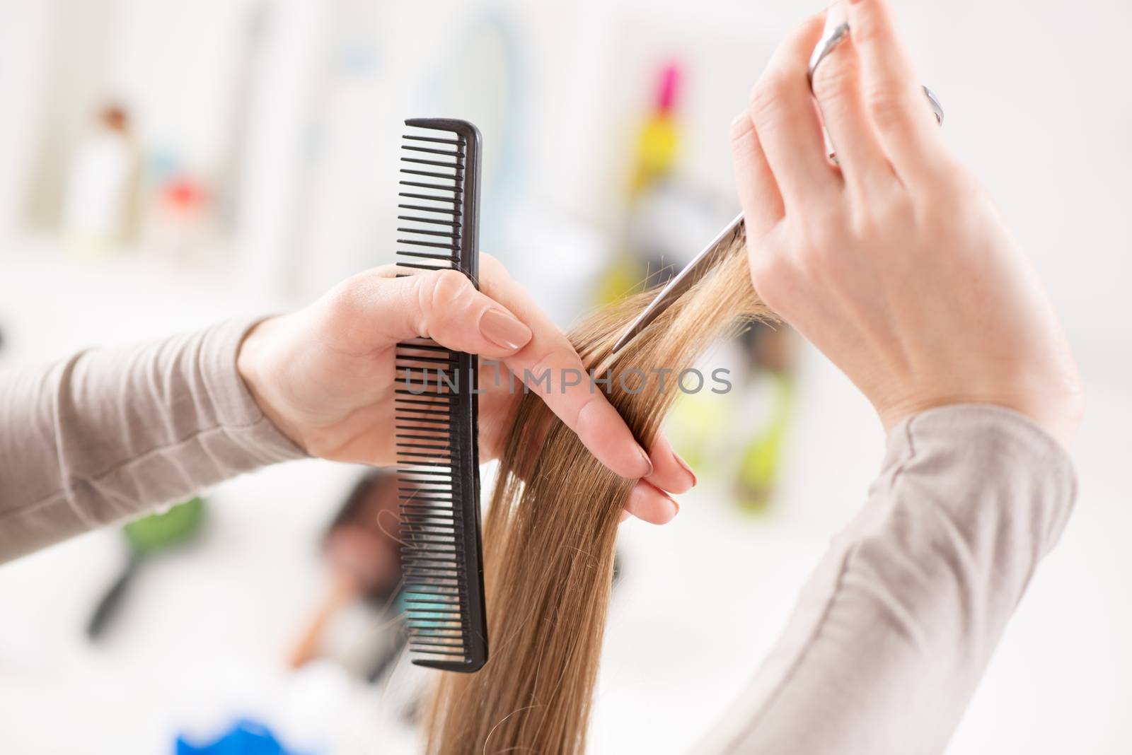 Hairdresser cut hair of a woman.