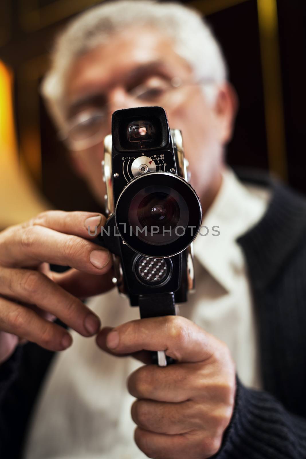 Senior man holding old fashioned Movie Camera.
