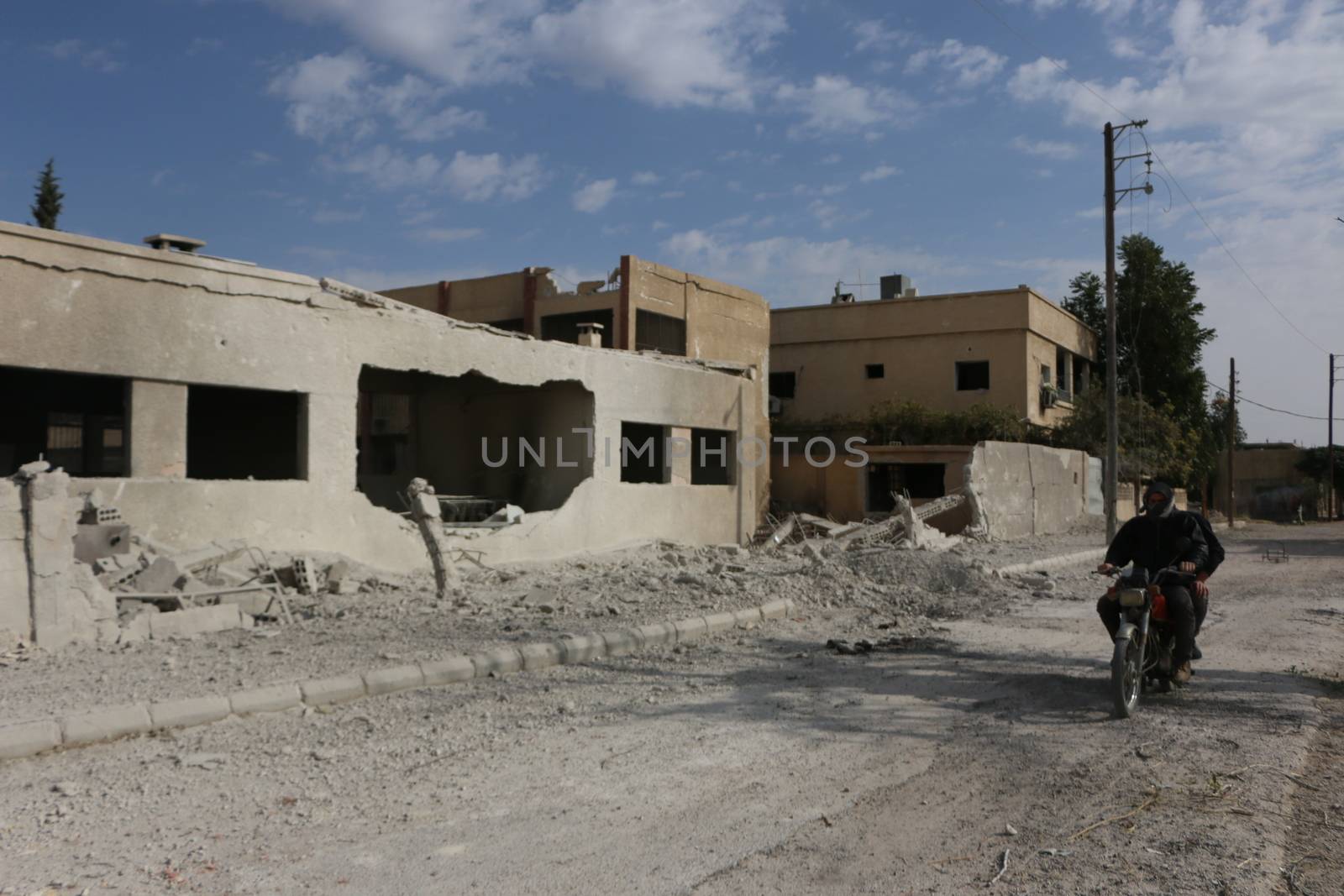 SYRIA, Damascus: A Syrian man drives a scooter amid damaged buildings in the Marj al-Sultan neighborhood in eastern Damascus on October 24, 2015.