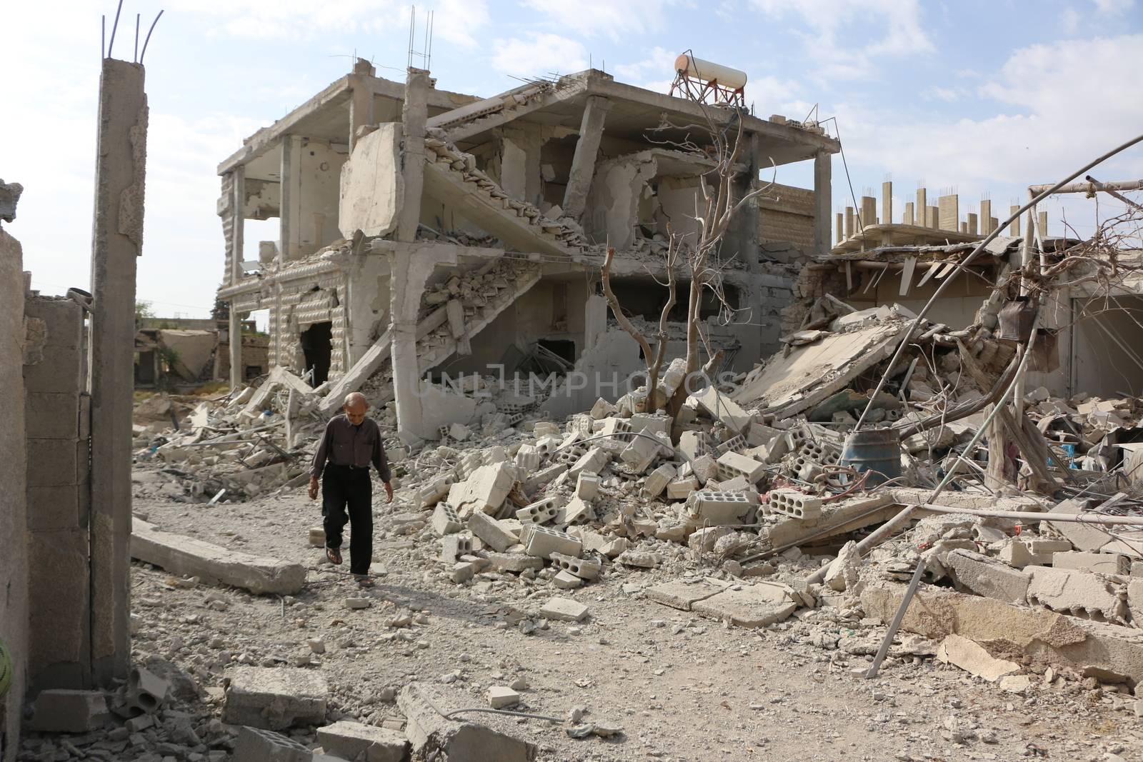 SYRIA, Damascus: A Syrian man walks amid damaged buildings in the Marj al-Sultan neighborhood in eastern Damascus on October 24, 2015.