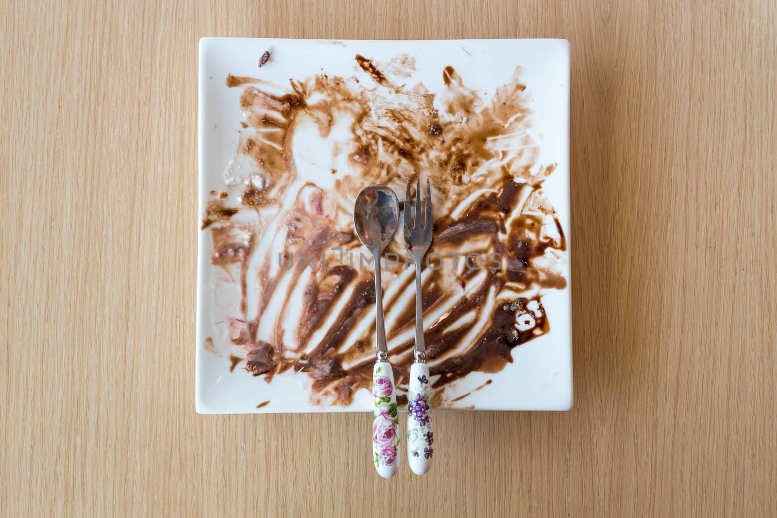 Leftovers of food on the white modern plate on wood background