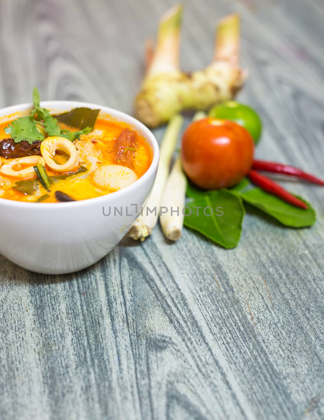 Closeup Tom Yum Kung-Thai spicy soup with Herb set of Tom Yum Soup Ingredients on wood background