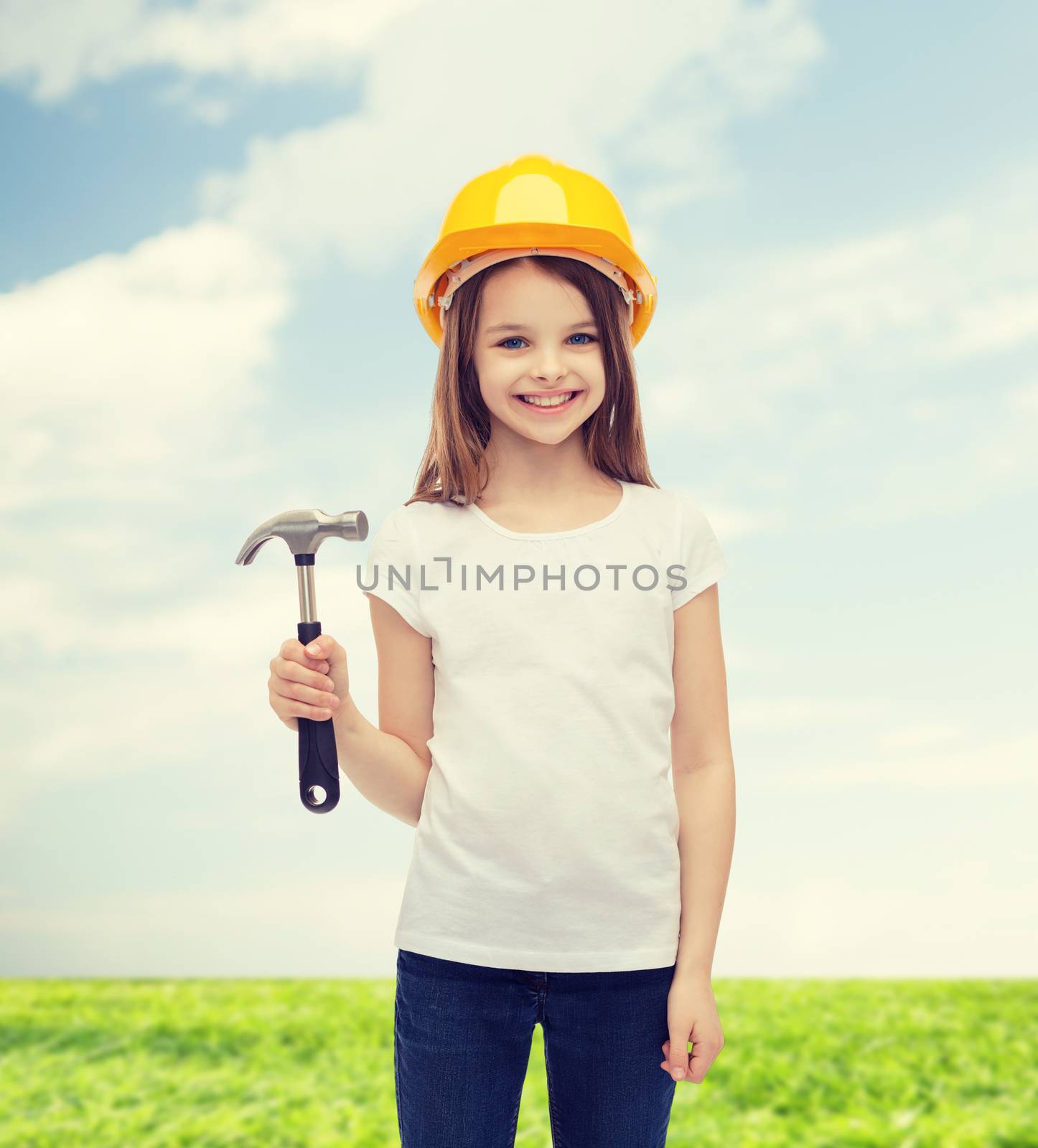 construction and people concept - smiling little girl in protective helmet with hammer
