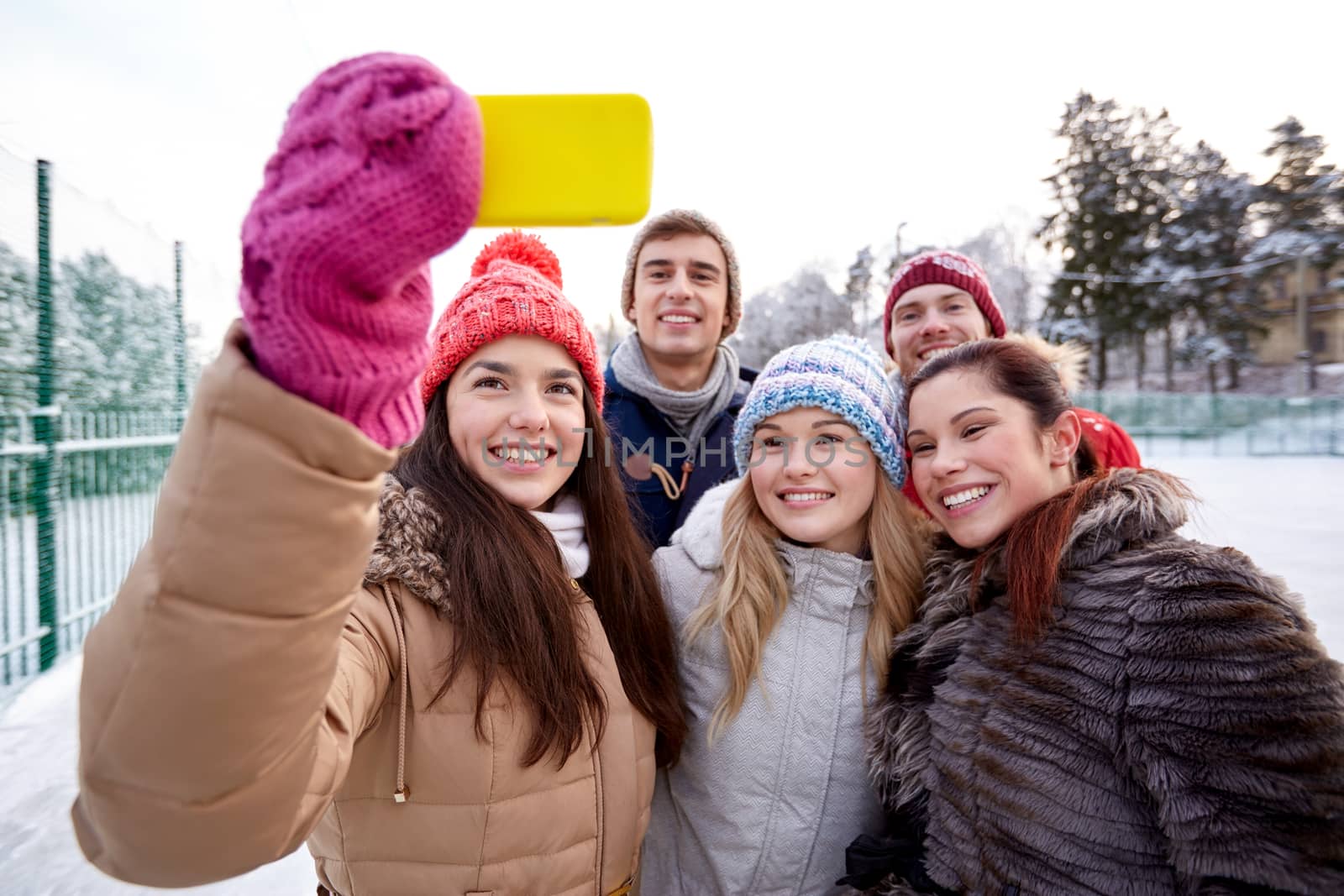 people, friendship, technology, winter and leisure concept - happy friends taking selfie with smartphone outdoors