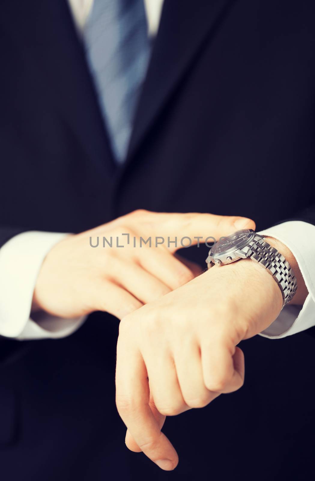 business people and office concept - close up of man looking at wristwatch