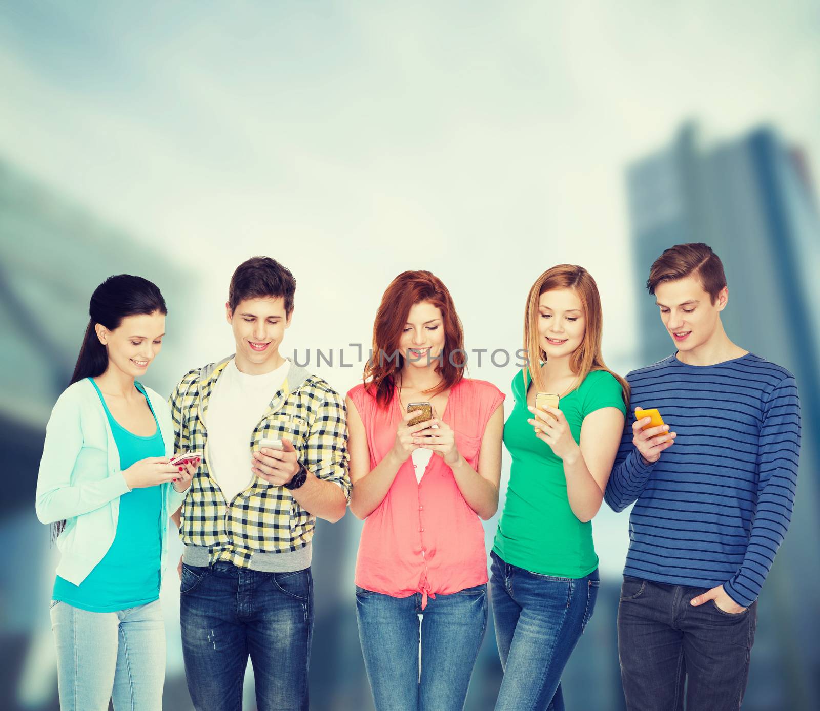 smiling students with smartphones by dolgachov