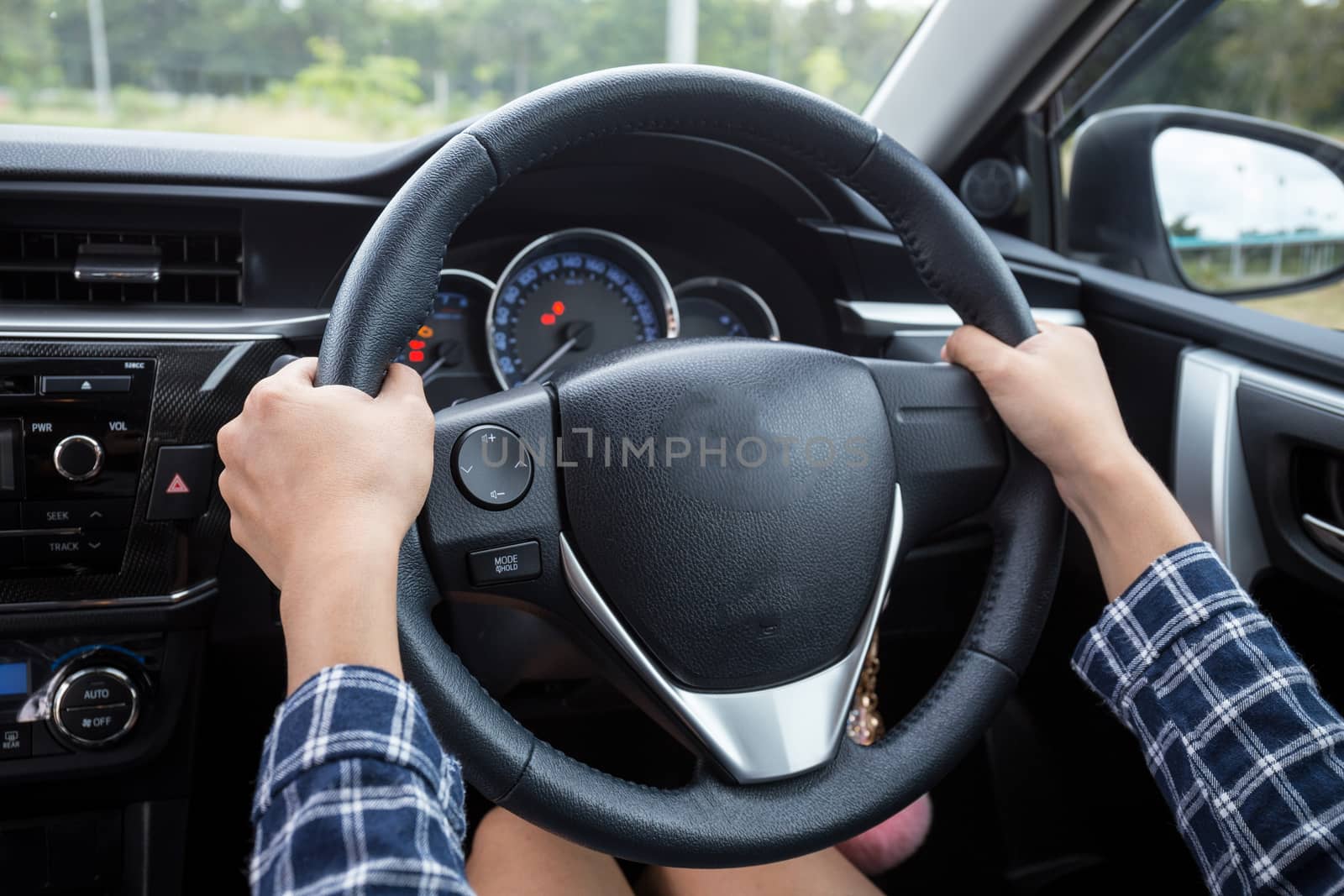 Close-up Of Woman's Hand Holding Steering Wheel for car driver by powerbeephoto