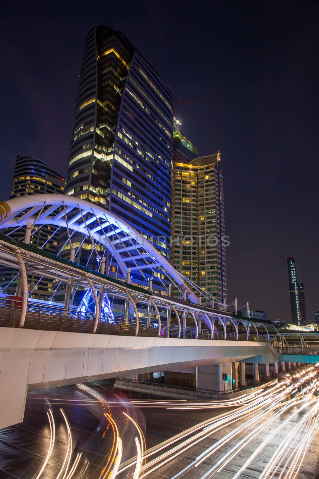 public skywalk at bangkok downtown square night in business zone by powerbeephoto