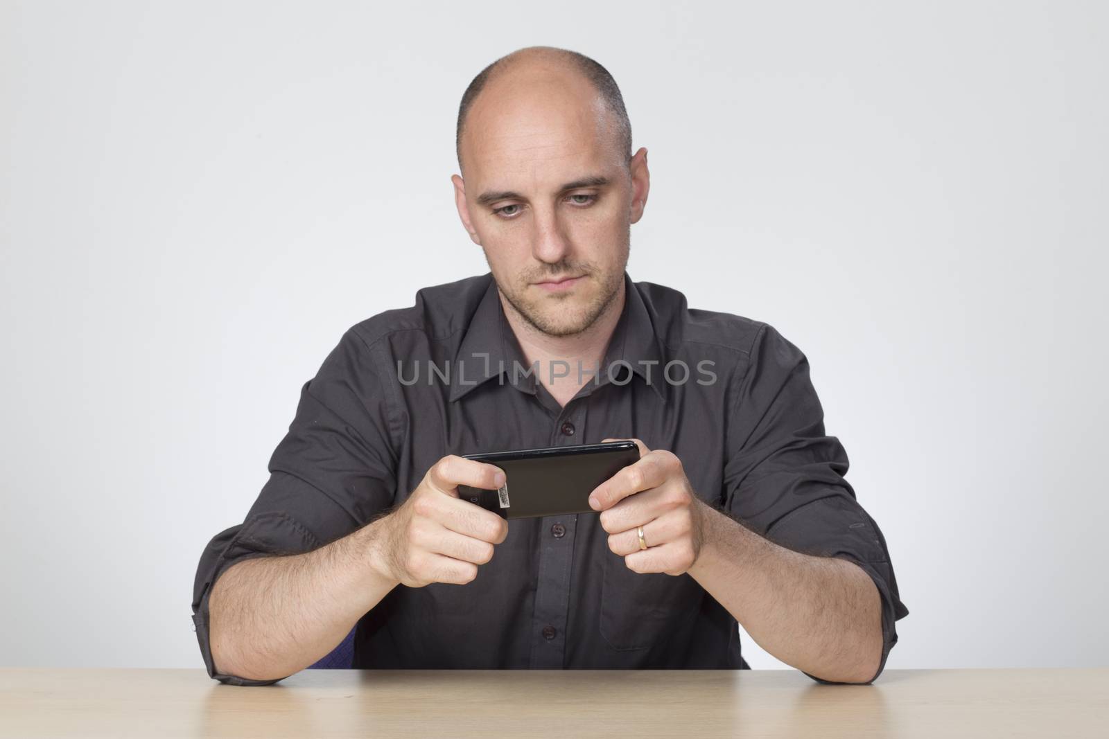 Man sat at desk playing on phone