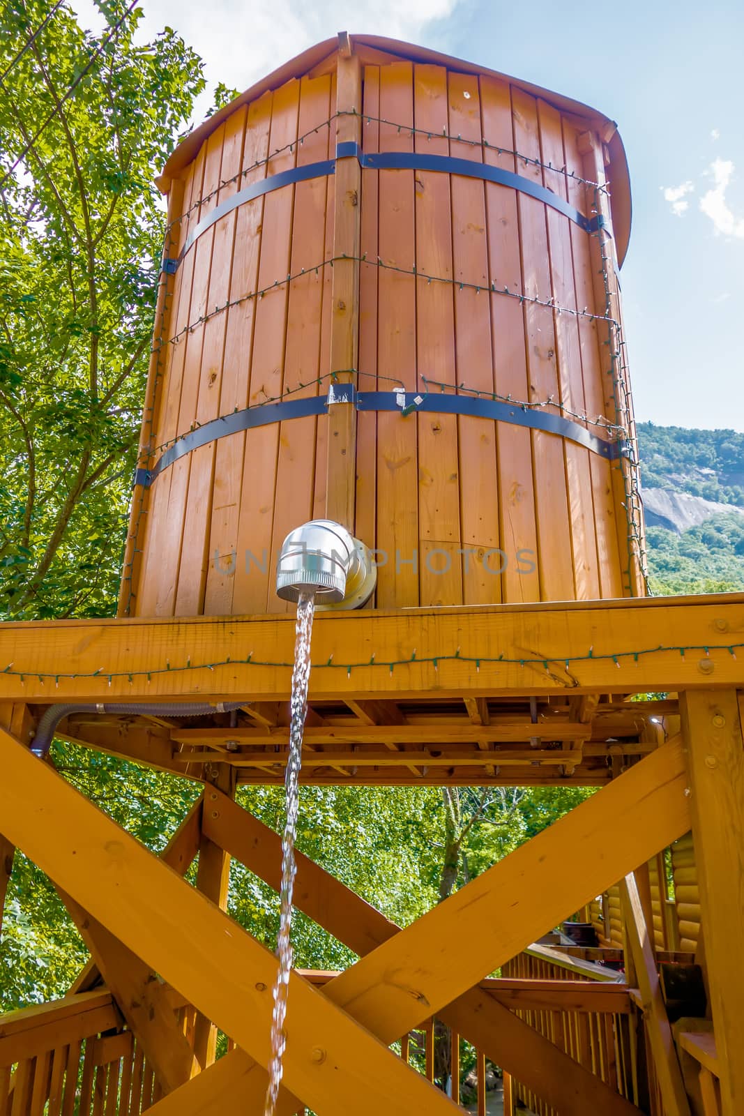 wooden bucket with water running from faucet