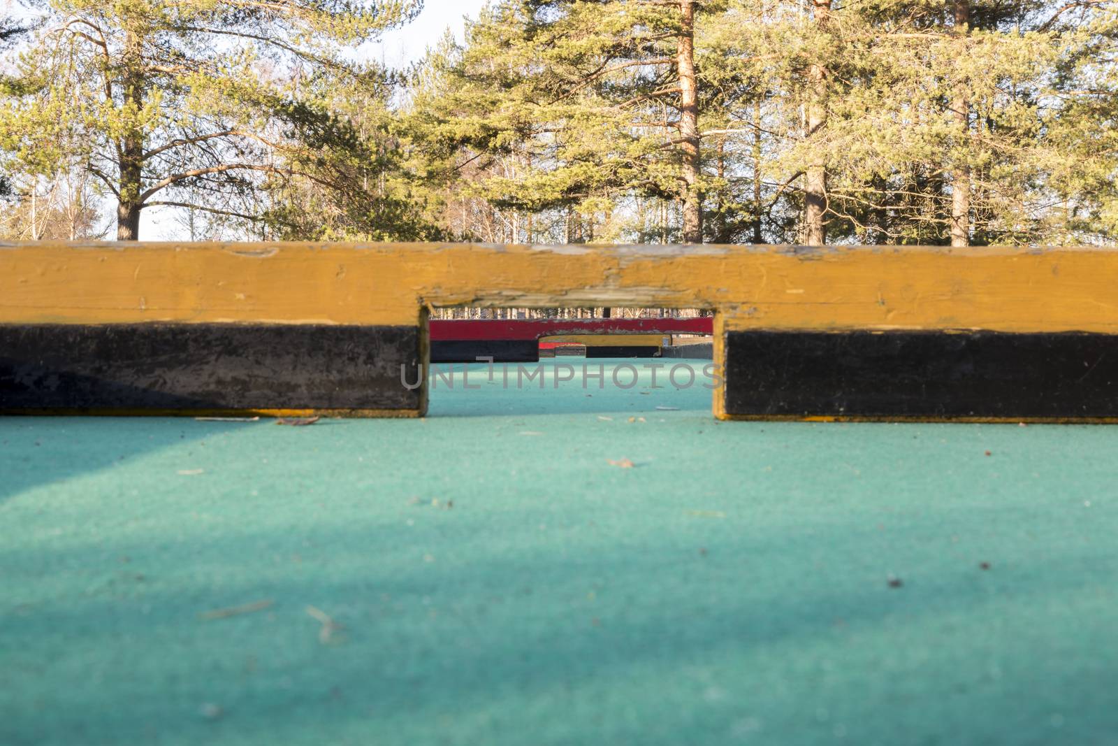 Miniature Golf Course close down with trees in the background.