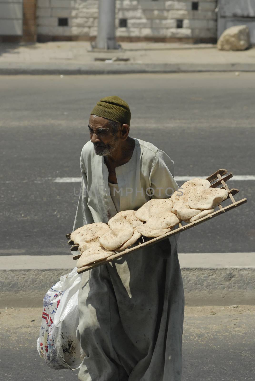 baker carries grain flat cakes by ssuaphoto